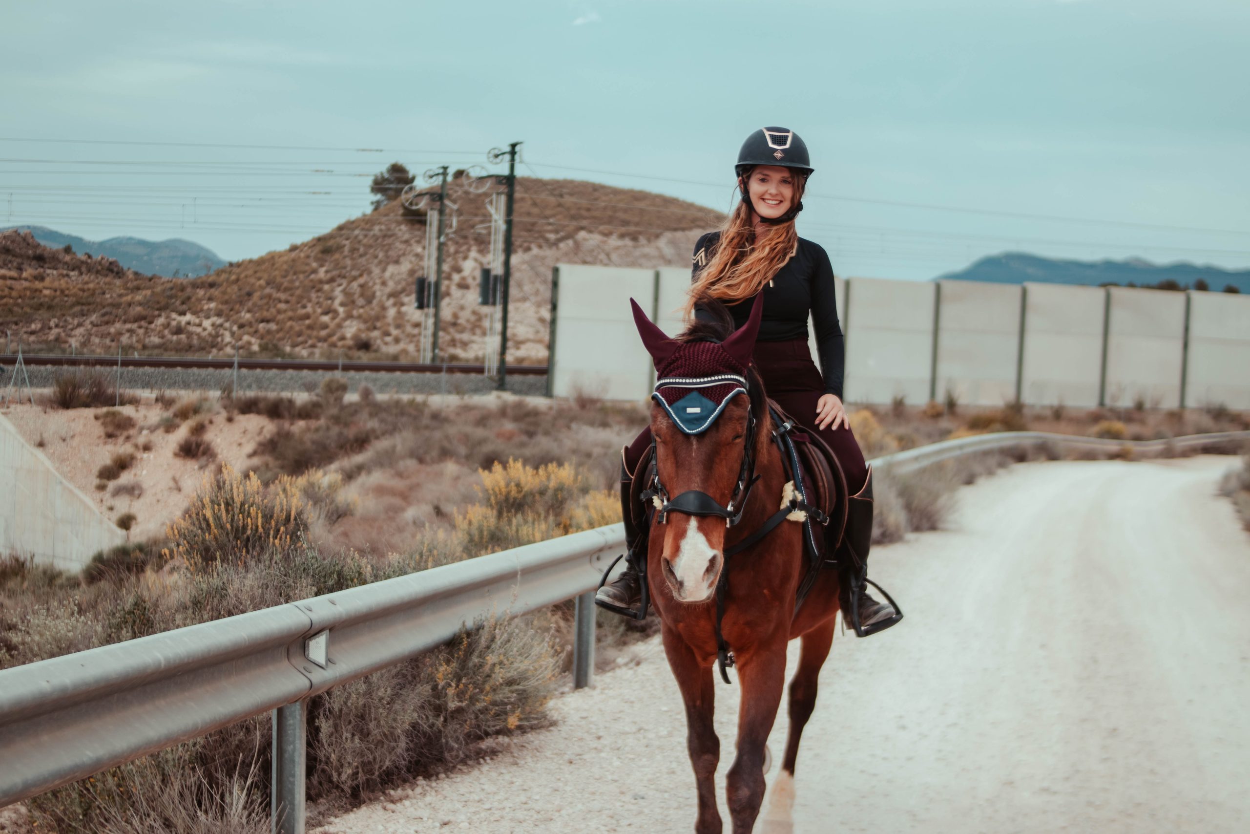 Rider walking his horse through the field while smiling